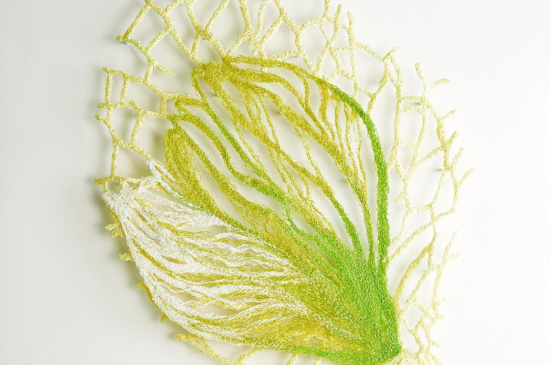 Gul flora, skulpturalt broderi (monterad i lådram bakom museiglas), 34x34 cm
