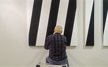 Torsten Ridell framför verk av konstnären själv.