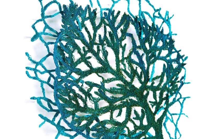 Grön växt, skulpturalt broderi (monterad i lådram bakom museiglas), 34x34 cm
